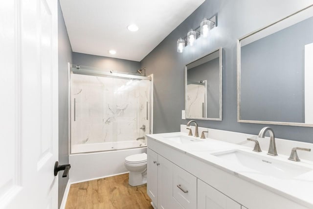 full bathroom featuring toilet, combined bath / shower with glass door, vanity, and wood-type flooring