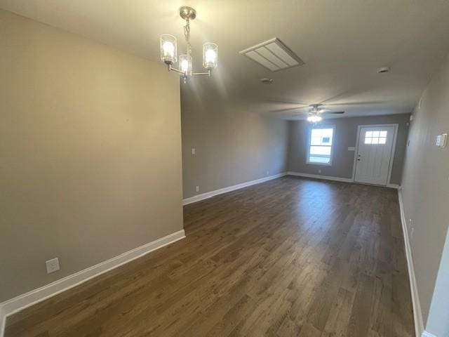 spare room with dark hardwood / wood-style floors and ceiling fan with notable chandelier