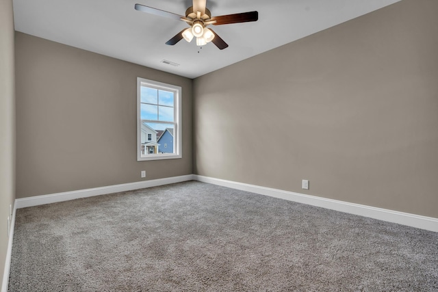 carpeted spare room with baseboards, visible vents, and ceiling fan