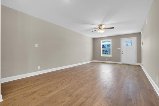 unfurnished room featuring wood-type flooring, ceiling fan, and baseboards