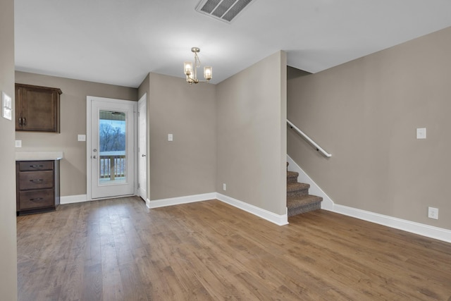 interior space featuring visible vents, stairway, baseboards, and wood finished floors