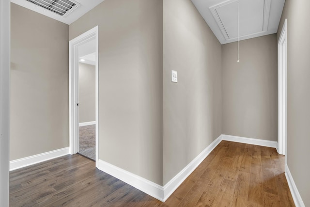 hallway featuring visible vents, wood finished floors, attic access, and baseboards