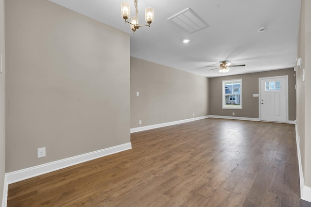 unfurnished room with baseboards, wood finished floors, and ceiling fan with notable chandelier