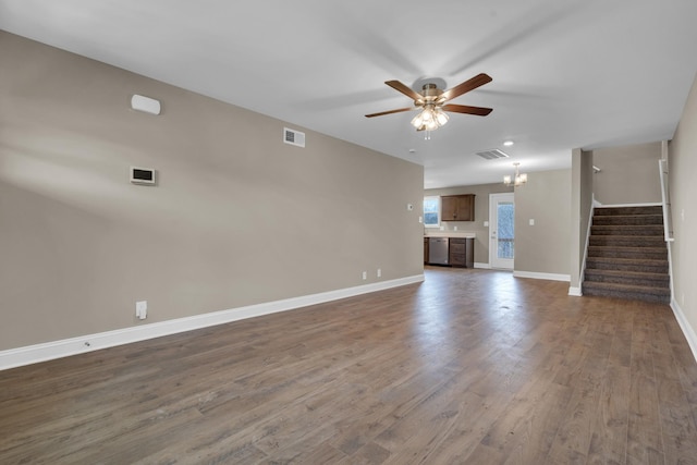 unfurnished living room featuring stairs, wood finished floors, visible vents, and baseboards