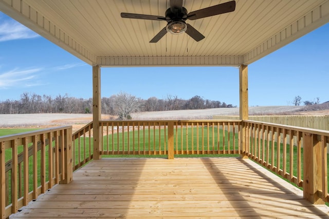 deck with a ceiling fan and a lawn