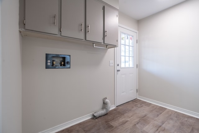 laundry room with cabinets, hookup for a washing machine, and light wood-type flooring