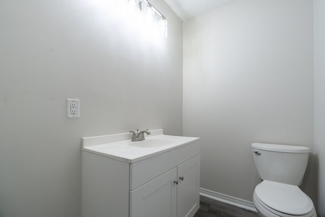 bathroom featuring hardwood / wood-style flooring, toilet, and vanity