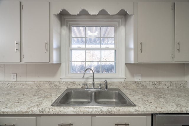 kitchen with sink, white cabinets, and dishwasher