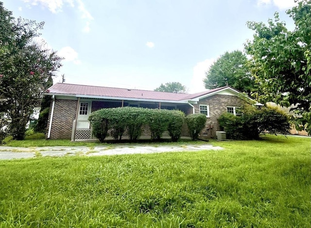 ranch-style house featuring central AC and a front yard