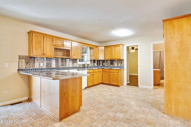 kitchen featuring backsplash, kitchen peninsula, dishwasher, ceiling fan, and sink