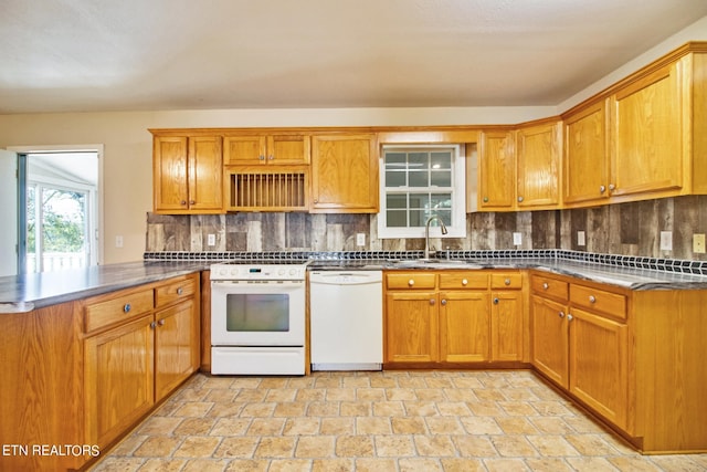 kitchen featuring backsplash, white appliances, kitchen peninsula, and sink