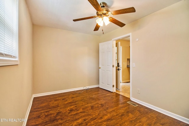 empty room featuring ceiling fan and dark wood-type flooring