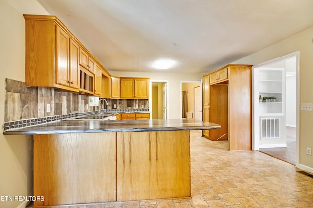 kitchen featuring kitchen peninsula, tasteful backsplash, and a breakfast bar area