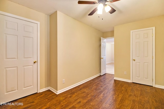 unfurnished bedroom featuring ceiling fan and dark hardwood / wood-style flooring