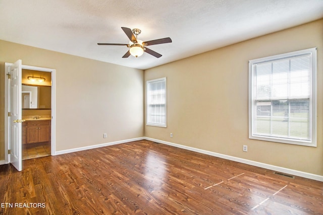 unfurnished room featuring ceiling fan, a textured ceiling, and dark hardwood / wood-style flooring