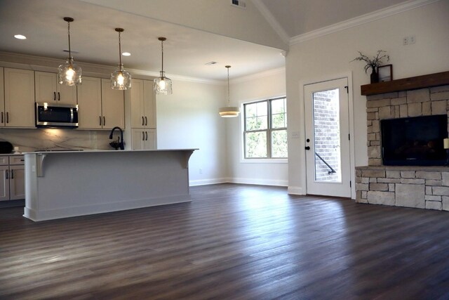 kitchen with a breakfast bar, backsplash, dark hardwood / wood-style flooring, crown molding, and decorative light fixtures