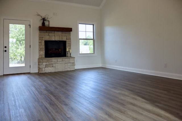 unfurnished living room featuring ornamental molding, a wealth of natural light, a fireplace, and dark hardwood / wood-style flooring