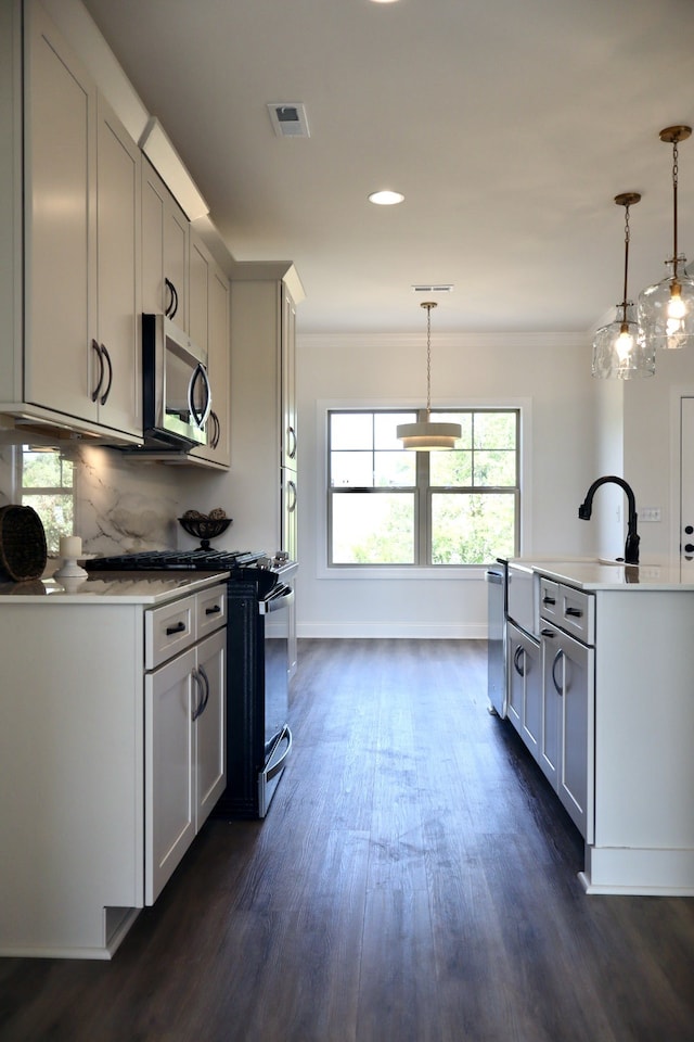 kitchen with appliances with stainless steel finishes, backsplash, decorative light fixtures, ornamental molding, and dark hardwood / wood-style floors