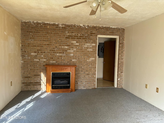 unfurnished living room with ceiling fan, carpet floors, electric panel, a glass covered fireplace, and a textured ceiling