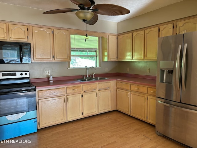 kitchen featuring a ceiling fan, a sink, light brown cabinetry, stainless steel appliances, and light wood-style floors