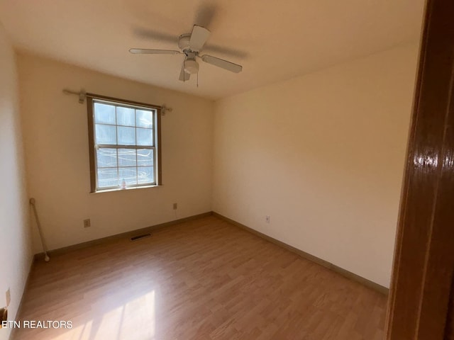 empty room with light wood finished floors, visible vents, ceiling fan, and baseboards