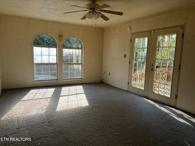 carpeted spare room with french doors, a textured ceiling, and ceiling fan