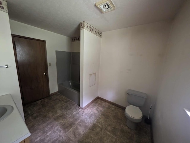 bathroom with a bathtub, toilet, vanity, and baseboards