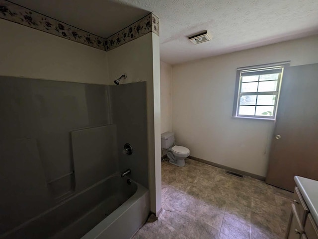 bathroom with vanity, baseboards, bathtub / shower combination, a textured ceiling, and toilet