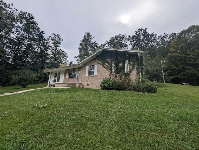 view of front of house with crawl space, brick siding, and a front yard