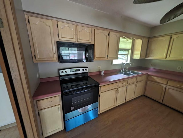 kitchen with stainless steel range with electric cooktop, wood finished floors, black microwave, and a sink