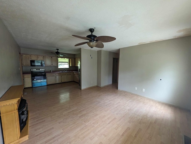 unfurnished living room with a textured ceiling, wood finished floors, visible vents, and a sink