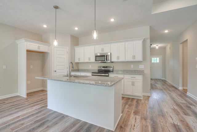 kitchen with white cabinetry, stainless steel appliances, sink, and pendant lighting