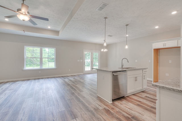 kitchen featuring white cabinetry, stainless steel dishwasher, sink, and light stone counters