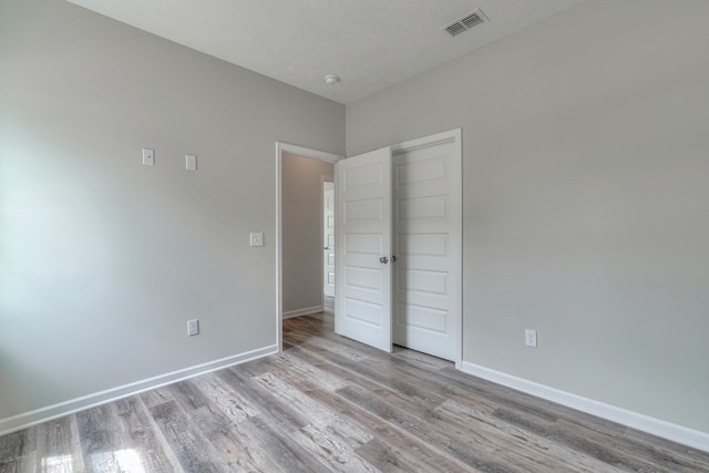 unfurnished bedroom with light hardwood / wood-style flooring and a closet