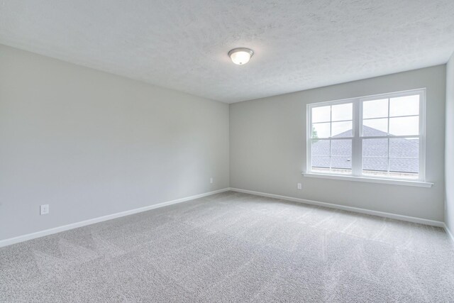 carpeted spare room with a textured ceiling