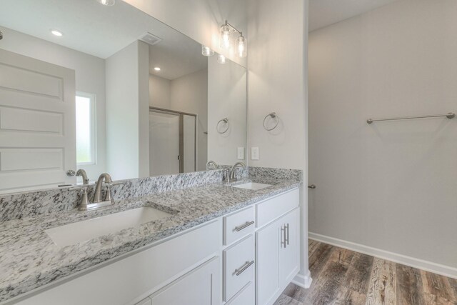 bathroom with an enclosed shower, hardwood / wood-style floors, and vanity