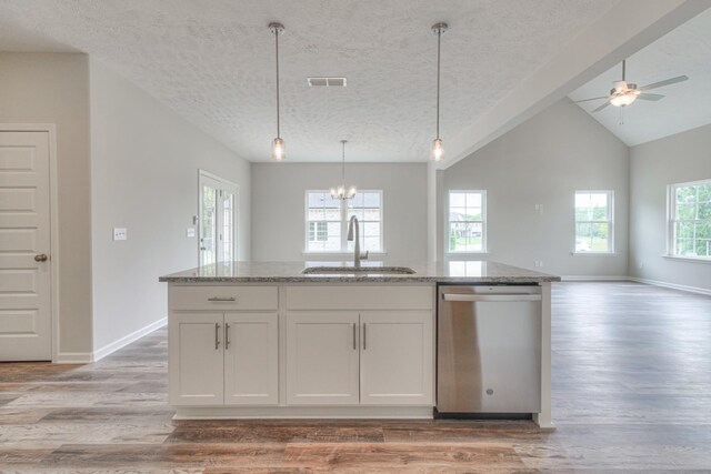 kitchen featuring pendant lighting, sink, dishwasher, white cabinetry, and light stone counters