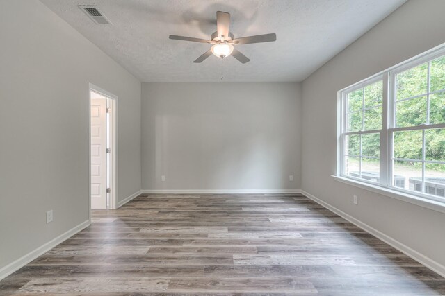 spare room featuring ceiling fan, hardwood / wood-style flooring, and a textured ceiling