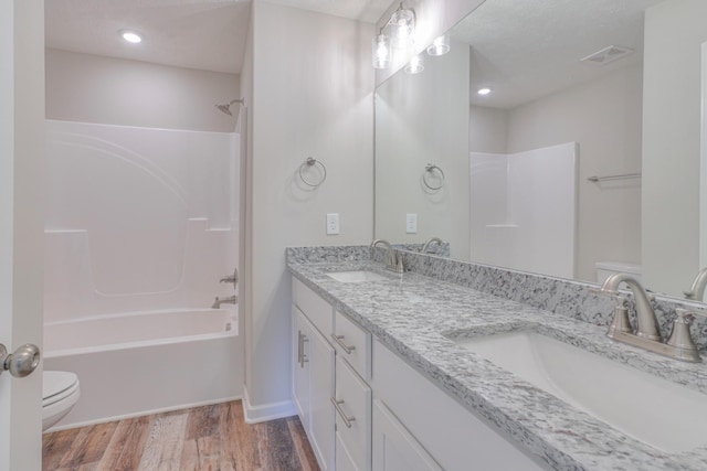 full bathroom featuring toilet, wood-type flooring, shower / washtub combination, and vanity