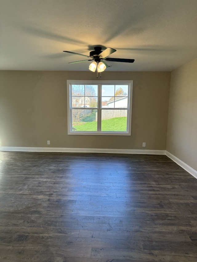 spare room with dark hardwood / wood-style floors, a textured ceiling, and ceiling fan