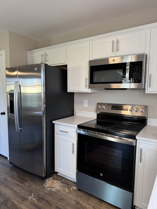 kitchen featuring dark wood-type flooring, white cabinets, and appliances with stainless steel finishes