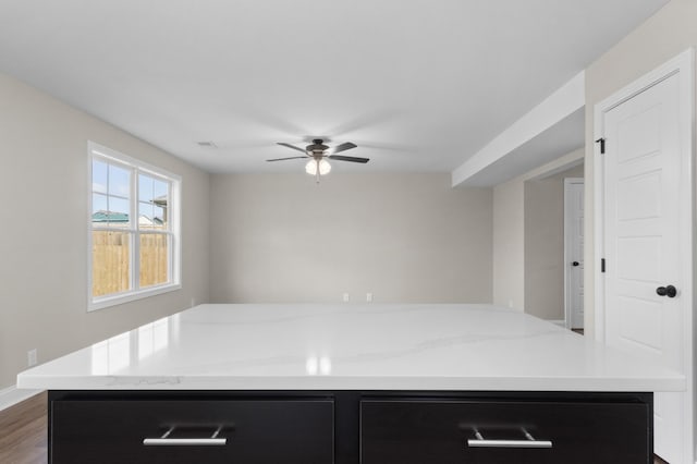 138 Anderson Pl, Clarksville, TN 37042 - kitchen with dark cabinetry, ceiling fan, light stone countertops, and a center island with sink