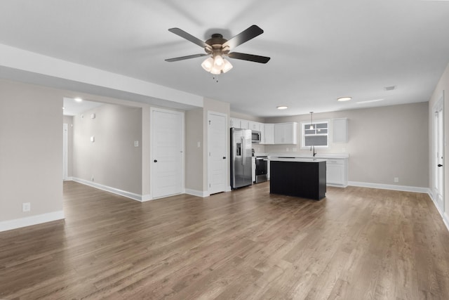 138 Anderson Pl, Clarksville, TN 37042 - interior space with white cabinets, a center island, stainless steel appliances, open floor plan, and a ceiling fan