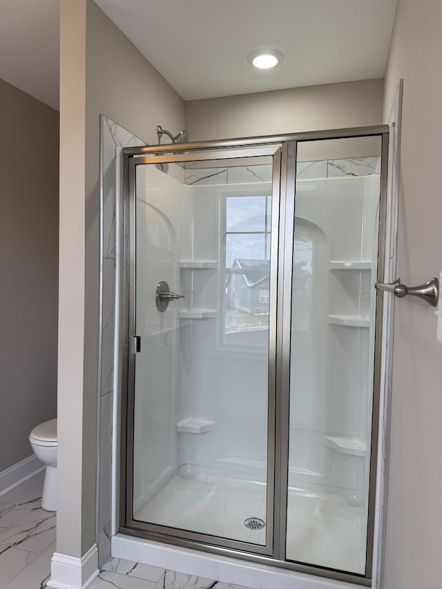 bathroom featuring toilet and an enclosed shower