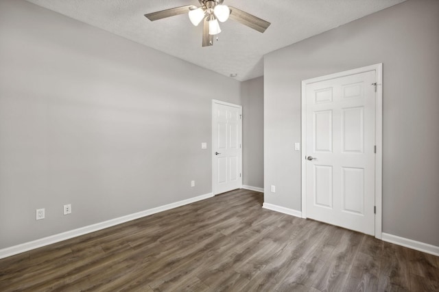 unfurnished bedroom with ceiling fan, dark hardwood / wood-style flooring, and a textured ceiling