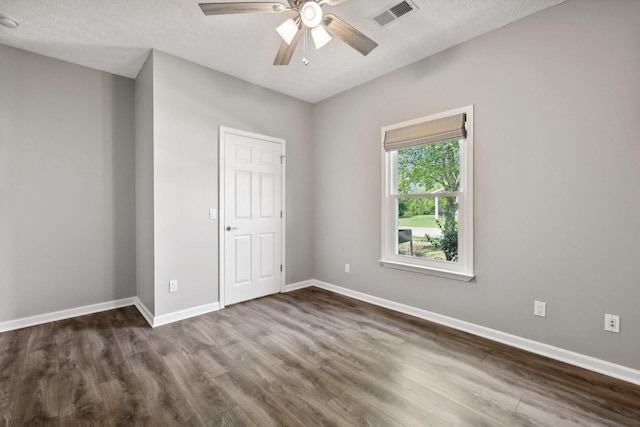 unfurnished bedroom with dark hardwood / wood-style flooring, ceiling fan, and a textured ceiling