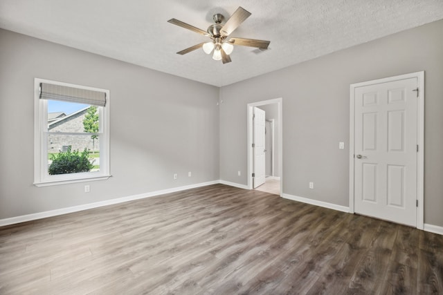 unfurnished room with a textured ceiling, hardwood / wood-style flooring, and ceiling fan