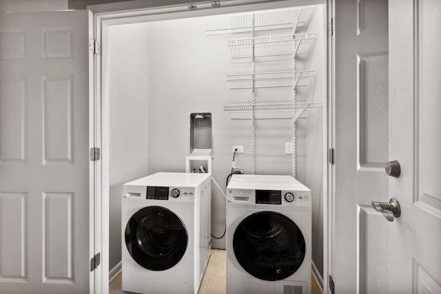 laundry room featuring light hardwood / wood-style floors and washing machine and dryer