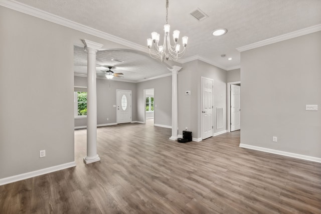 unfurnished dining area featuring a textured ceiling, ceiling fan with notable chandelier, wood-type flooring, and ornamental molding