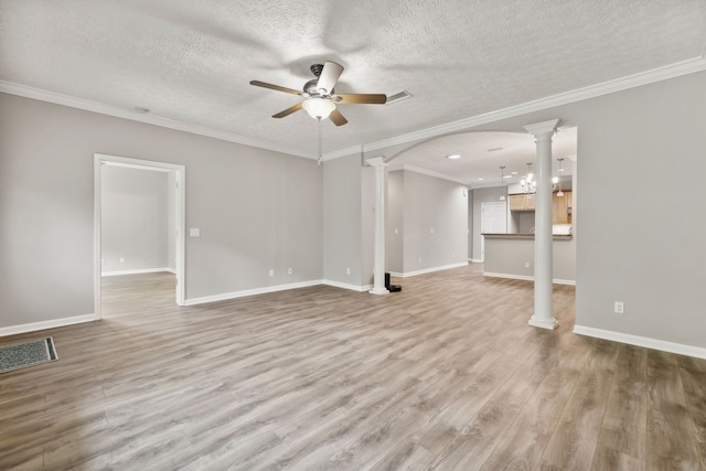 unfurnished living room with hardwood / wood-style flooring, ornate columns, ceiling fan, and crown molding